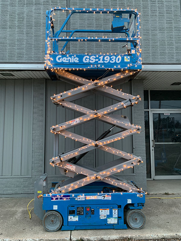 Scissor lift with Christmas lights on it